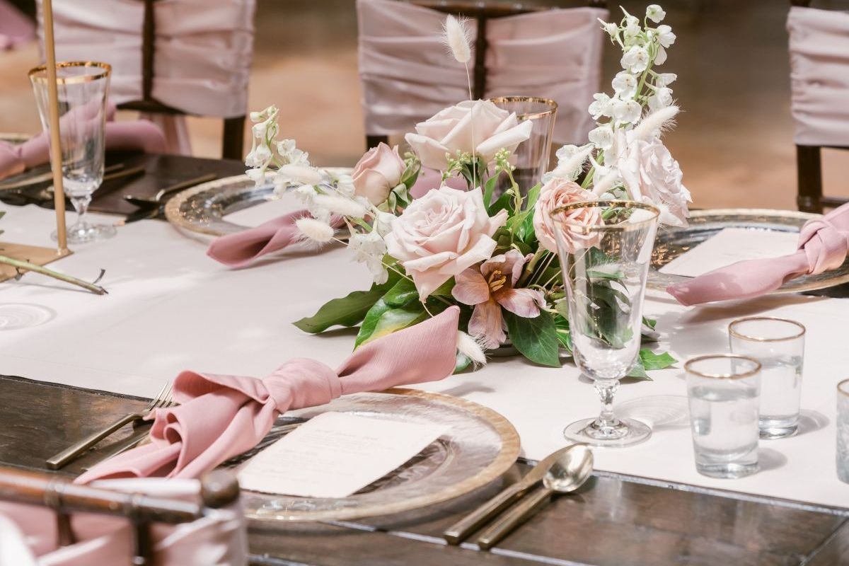 Wedding table layout with pink linens and pink rose centerpieces