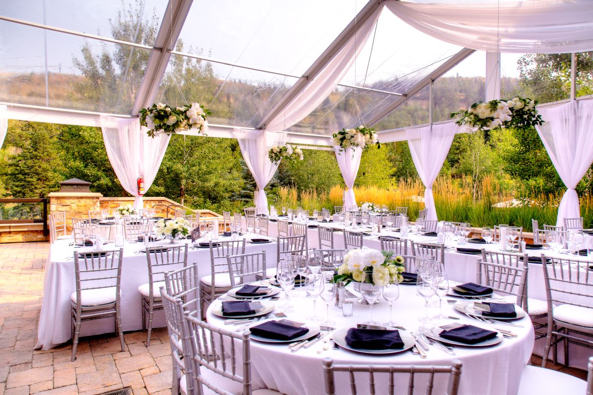 Table arrangement in open tent for outdoor wedding