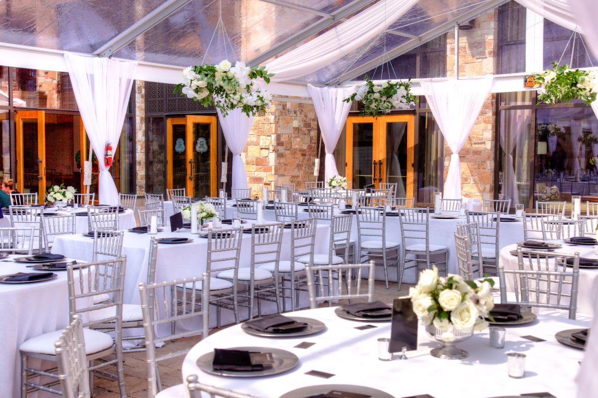 Interior of open tent for outdoor weddings, featuring drapes